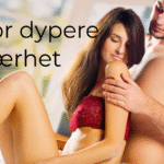 Par sitter i en seng, kvinne med ryggen lent mot sin mann. Han stryker sensuelt på henne.