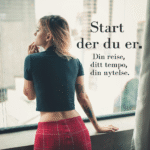 Kvinne ser ut over byen fra et vindu, kledd i rødt og sort – et stille øyeblikk av refleksjon og selvutforsking.