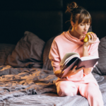 kvinne som sitter på sengen og leser og reflekterer over egne tanker og seksualitet