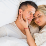 par som ligger tett sammen i sengen og viser nærhet og tillit i forhold